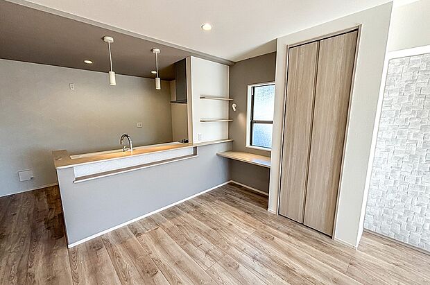 家事の音が響くダイニングで、家族の会話が弾むひととき。造作カウンターとニッチが、心地よい時間をそっと彩ります。（2号棟）