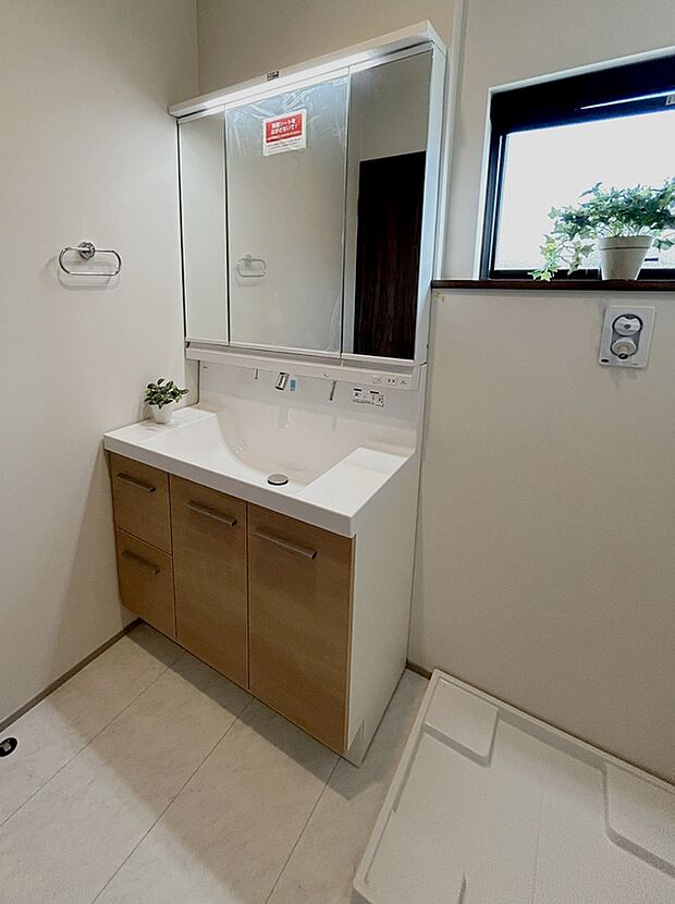 【２号棟洗面台】幅９０cmのワイドタイプ。三面鏡の大きく、ボウル脇に小物を置くときにも便利です。