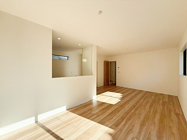 【リビング】南西向きの大きな窓からたっぷりと陽光が差し込み、お部屋の隅々まで明るく照らします。 ナチュラルな木目調のフローリングが光を優しく反射し、家族が自然と集まりたくなるような温かな空間を演出。