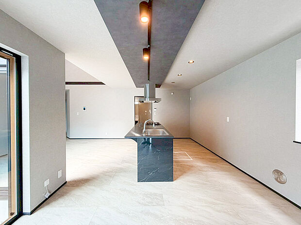 【キッチン】室内は白を基調とした洗練されたデザインで、木目調のアクセントが温かみを添えるモダンな仕上がりです 。家族が集まり、ゆったりと寛げる工夫が随所に散りばめられた、憧れの平屋ライフを叶えるリビングです 。