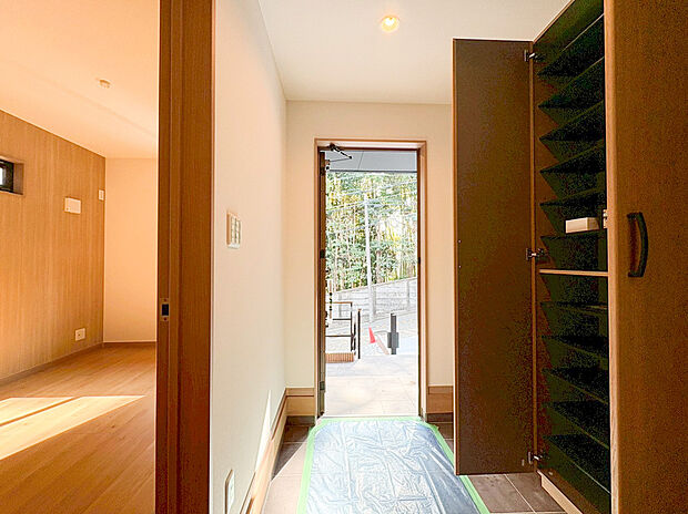 【玄関収納】扉を開けた瞬間に広がる、明るく清潔感のある玄関です 。南西側からの自然光が差し込み、毎朝の出発を爽やかに演出します 。大容量のシューズボックスを完備しているため、家族全員の靴をスッキリと収納できます。