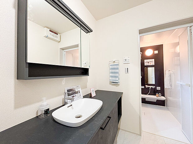 【洗面化粧台】インテリアのような美しさを放つ、ワイドなベッセル式の洗面化粧台を採用しました 。シックなグレーの天板と大容量の鏡が、毎日の身支度を贅沢な時間へと変えてくれます 。