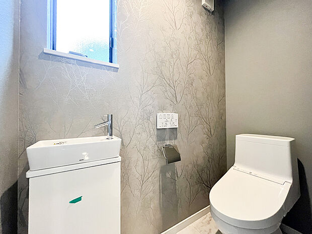 【ウォシュレットトイレ】衛生面に配慮した独立型の手洗いカウンターを設置し、ゲストも気兼ねなく利用できる機能的な設計。お手入れしやすいタンクレストイレ風のデザインと、大理石調の床が高級感をさらに引き立てます。