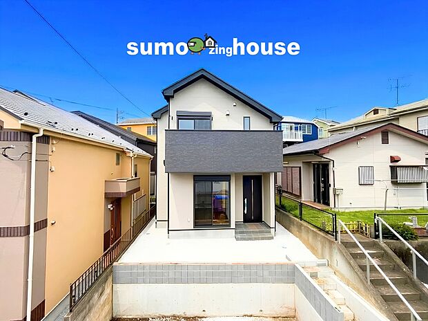 【駐車並列2台可能な新築オール電化デザイナーズ住宅】外観は清潔感のある白の壁面とシックで洗練されたダークグレーを組み合わせたモダンなデザインとなっており、周辺の穏やかな街並みや緑豊かなロケーションに見事に調和するおしゃれな佇まいです。