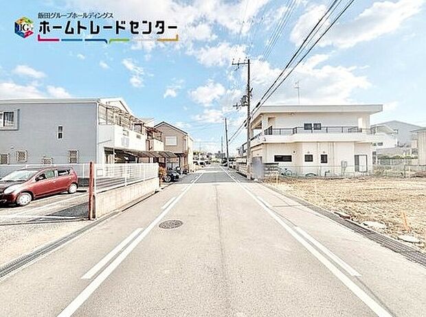 【前面道路含む現地写真】道路幅は約８ｍあるので、運転が苦手な方でも楽々駐車できます♪電柱から建物まで距離があるのは、防犯面でも良いポイントです。

