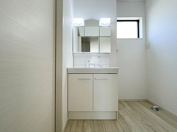 【洗面台・洗面所】大きく見やすい三面鏡で清潔感ある洗面所は、身だしなみチェックや肌のお手入れに最適です。何かと物が増える場所だからこそ、スッキリと見映えの良い空間に拵えました。