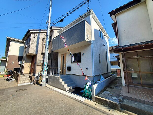 外観は白とグレーを組み合わせたスタイリッシュなデザイン。玄関まわりもきれいに整い、第一印象の良い住まいです。完成済で実際の明るさや雰囲気を確認できます。