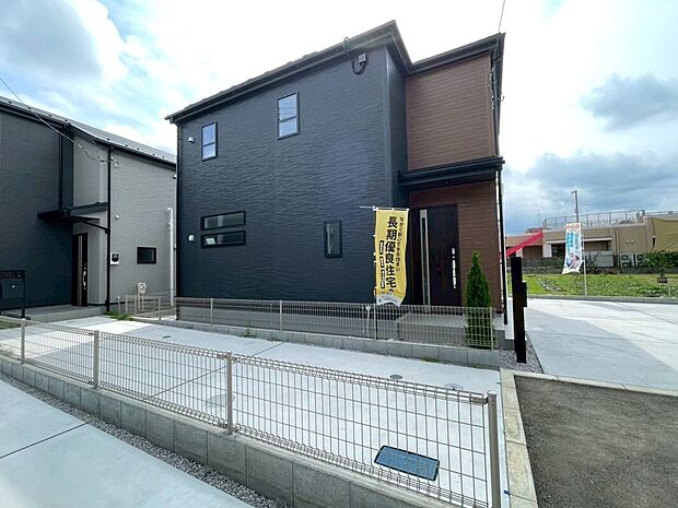 【外観(分譲地内・駐車2台)】黒系と木調の外壁の2階建。