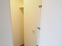 洋服を掛けられるハンガーパイプと枕棚のある収納力たっぷりのウォークインクローゼットです。上着を掛けた下に整理箪笥や衣装ケースを置いて効率的に空間を利用出来ます。