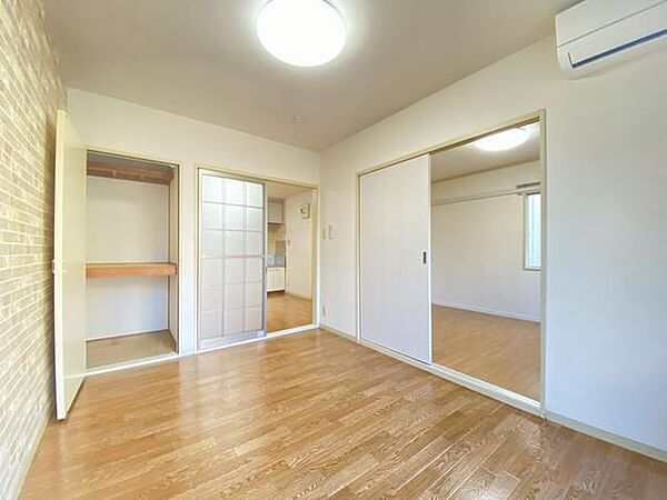 画像4:キッチンと続きの洋室はオシャレなアクセントクロスとナチュラルカラーな床材