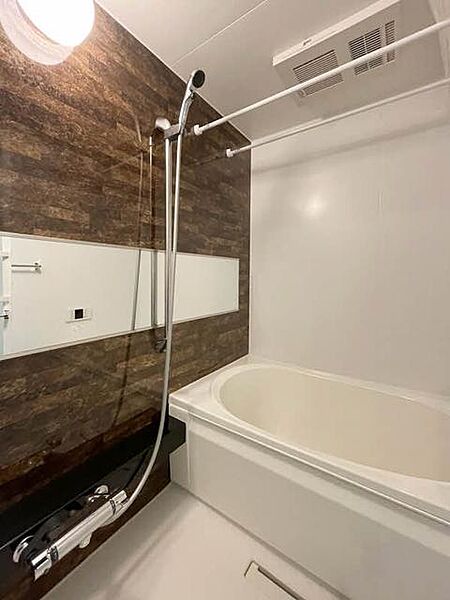 画像6:【浴室】1318サイズの浴室は、洗い場もしっかり確保できているので、立ったり座ったりの浴室内動作も、スムーズです。メタリックシャワーヘッドとブラウンのアクセント壁で高級感があります。