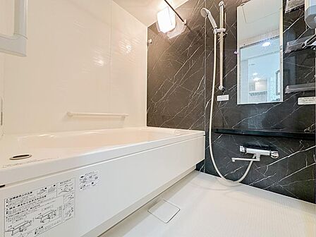 大理石調のアクセントパネルが、上質で落ち着いた雰囲気を演出するバスルーム。ゆったりと湯船につかり、一日の疲れを癒やせます。毎日の入浴が楽しみになる、ホテルライクで寛ぎに満ちた空間です。