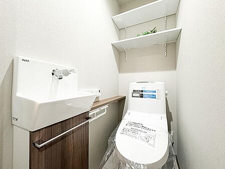 すぐに手が洗える洗面台や、小物が置けるカウンター付き。上部の棚はトイレットペーパー収納やディスプレイにも便利です。機能的でスッキリ整う心地よいレストルームです。