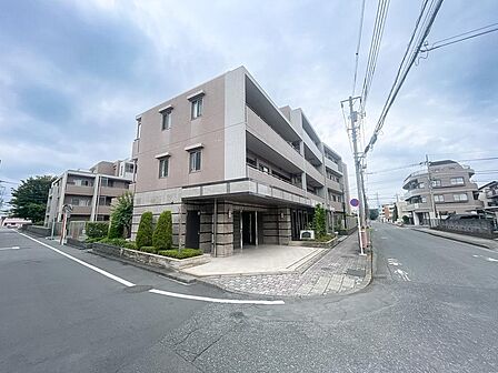 重厚感あふれるタイル貼りの洗練された外観。角地に位置し日当たり・風通りともに恵まれた良好な住環境。