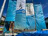 外観：「地震に強い家」の安心構造！青空に映える養生シートの下で着々と工事が進む期待の新築住宅。