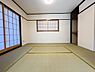 寝室：陽光が優しく差し込む和室。畳の香りに包まれ、お子様のお昼寝や家族団らんのひとときを過ごすのに最適です。多目的に使える落ち着いた空間が魅力です。