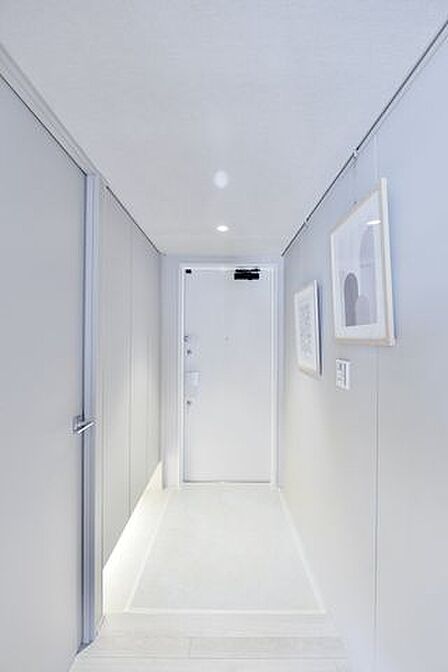 スタイリッシュなホワイトを基調にした玄関、ピクチャーレールを設置していますので、空間をお好みのアートやグリーンで彩っていただけます。人感センサーライト設置済みで手がふさがっている時も安心です。