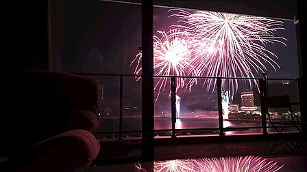 室内から望む海上花火大会を望む。