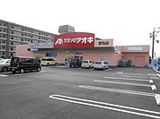 銀行「クスリのアオキまで190m」