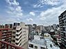 バルコニー：バルコニーからの眺望。周囲の街並みを見渡せる、開放感のある景色が広がります。