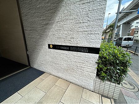 『シティインデックス西日暮里』の館銘板。エントランス周りも落ち着いたデザインでまとめられています。