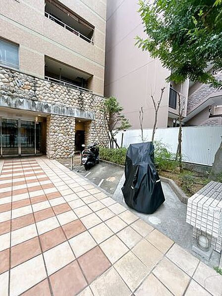 【共用部】建物入り口付近の写真です。バイク置き場があります。