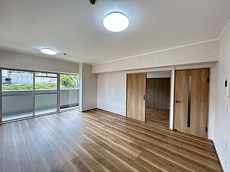 【リフォーム済】角部屋で、リビングは南側と東側バルコニーに面した日当たりのよい部屋です。和室との間にあった収納壁を解体して拡張しました。