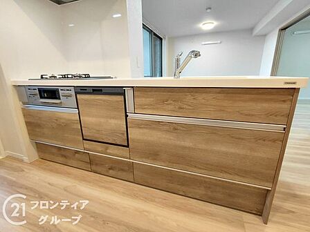 美しい木目調のパネルが印象的な、家具のようなキッチンです。リビングと一体感のある設計で、家族との会話も自然に弾みます