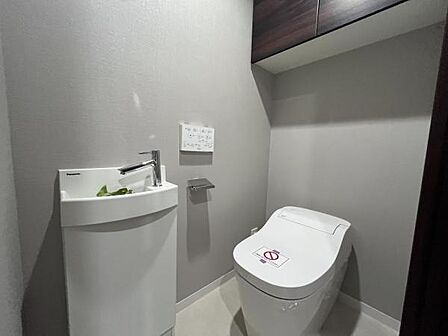 ～トイレ～ 上部に吊戸棚が設置された温水洗浄機能が完備されたトイレです。