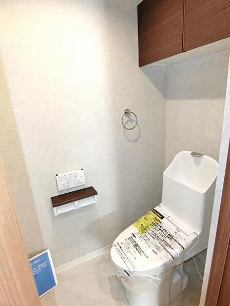 シャワー機能付トイレ。トイレ用品などの収納に便利な吊戸棚を設置しました。
