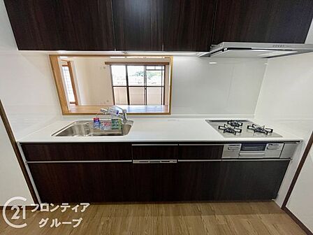シックな木目調のパネルが空間を引き締める高級感漂うシステムキッチン。ゆとりある調理スペースと使い勝手の良い家事動線が確保されており、毎日の料理の時間をより豊かでクリエイティブなものにしてくれます