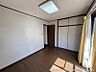 その他：採光の良い洋室は、収納も備わり、プライベート空間としても活用いただけます。床の木目と白い壁が落ち着いた雰囲気を演出します。