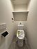トイレ：機能的な温水洗浄便座と、トイレットペーパーホルダー、上部には収納棚も備わっています。快適なプライベート空間を演出します。