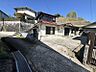 外観：小高い丘の麓、穏やかな日差しが差し込む住宅地。現況での引き渡しの物件です。広々とした敷地で、リノベーションや建て替えをご検討の方におすすめです。