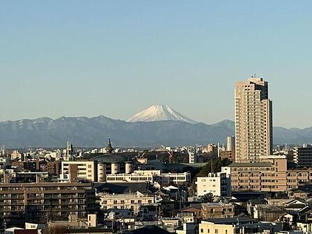 バルコニーからは周囲のマンションや住宅が立ち並ぶ市街地の風景とともに、遠方には冠雪した山々や広がりのある連山を望むことができるロケーションとなっております。