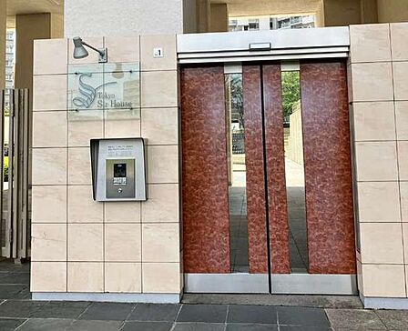 ベージュ調のタイル貼りの外壁には集合操作盤付きのオートロックシステムが設置されており、木目調とスリットガラスを組み合わせた自動ドア仕様のエントランスとなっております。
