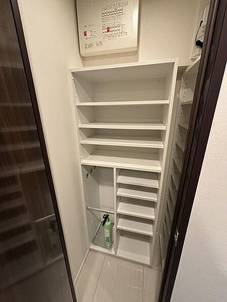 棚の高さを調整できる可動棚を備えたホワイト基調の作り付け収納で、上部には分電盤が設置されており、靴や日用品などの小物を細かく分類してすっきりと整理・収納することが可能です。