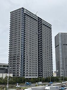 外観：白と黒を基調としたシックなカラーリングの外観で、各階にガラス手摺を設けたバルコニーラインが整然と配置された、モダンでスタイリッシュなデザインの高層マンションです。