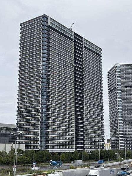 白と黒を基調としたシックなカラーリングの外観で、各階にガラス手摺を設けたバルコニーラインが整然と配置された、モダンでスタイリッシュなデザインの高層マンションです。