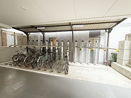 大切な自転車を雨から守る屋根付きの駐輪場。整理された2段式ラックで安心して駐車できます。