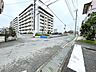 外観：前面道路から見たマンション周辺の様子です。道路との接し方や建物へのアプローチをイメージしやすい写真です。
