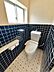 トイレ：清潔感のある独立したトイレです。小窓から光が差し込み、換気も可能。ネイビーのタイルと個性的なフロアデザインが魅力です。