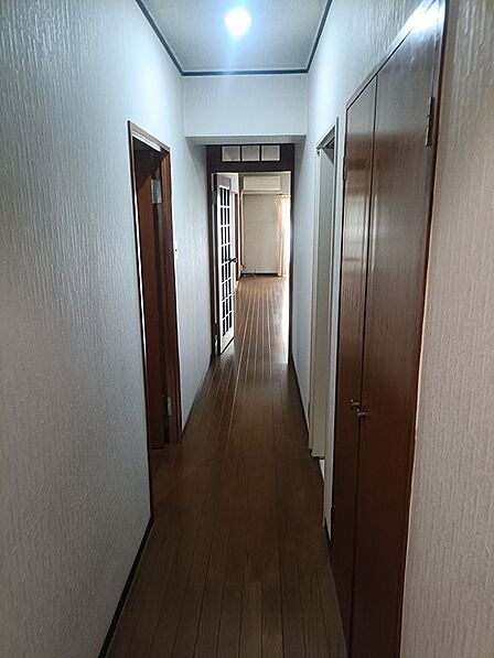 玄関から奥へ続く廊下は、居住空間へと期待を高めます。明るい床と白い壁が、日々の暮らしを彩ります。