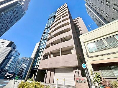 外観：陽の光に包まれ、青空と調和する洗練された住まい。心地よさと上質さを兼ね備えた邸宅です。