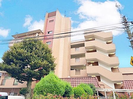 街並みに自然と馴染む色を基調とした外観は、温かみのある色合いが全体を包み、やさしい雰囲気を感じます。(空の加工を生成AIで行っています)
