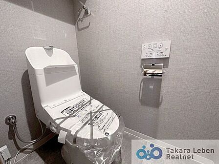 ウォシュレット機能付きのトイレは壁掛けリモコンの上位グレードを採用。便座がスッキリした印象となり、限られた空間を広く見せる効果があります。