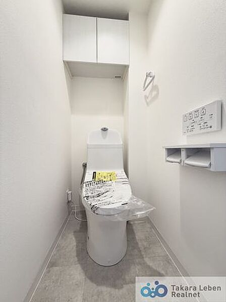 ウォシュレット機能付きのトイレは壁掛けリモコンの上位グレードを採用。便座がスッキリした印象となり、限られた空間を広く見せる効果があります。