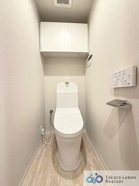 ウォシュレット機能付きのトイレは壁掛けリモコンの上位グレードを採用。便座がスッキリした印象となり、限られた空間を広く見せる効果があります。