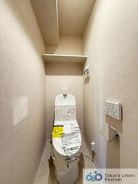 ウォシュレット機能付きのトイレは壁掛けリモコンの上位グレードを採用。便座がスッキリした印象となり、限られた空間を広く見せる効果があります。