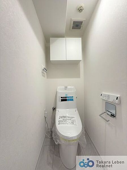 ウォシュレット機能付きのトイレは壁掛けリモコンの上位グレードを採用。便座がスッキリした印象となり、限られた空間を広く見せる効果があります。